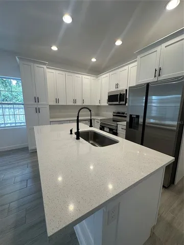 a kitchen with stainless steel appliances a refrigerator sink microwave and cabinets