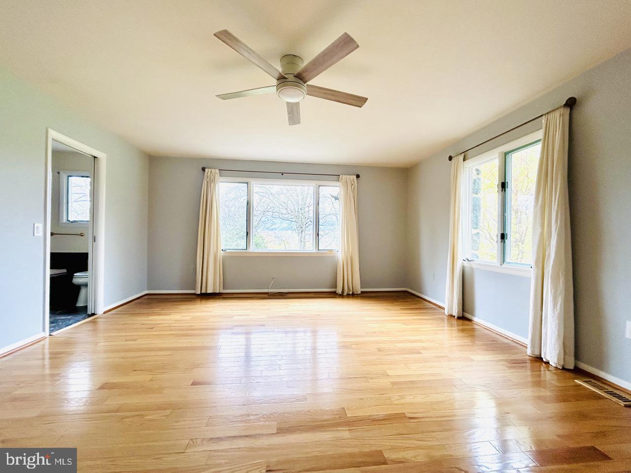 14820 Old York Road Phoenix, MD 21131 - Photo 15 of 22 an empty room with wooden floor a ceiling fan and windows