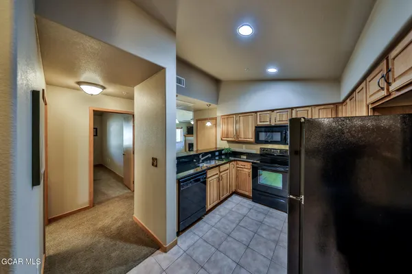 a kitchen with stainless steel appliances granite countertop a refrigerator and a sink
