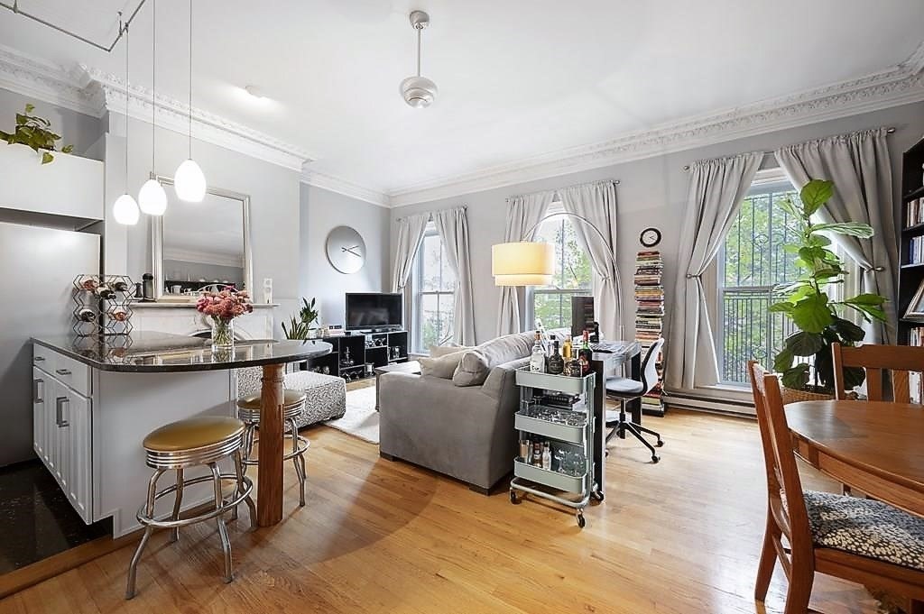 a living room with fireplace furniture and a large window