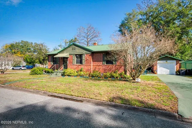 a front view of house with yard and trees around