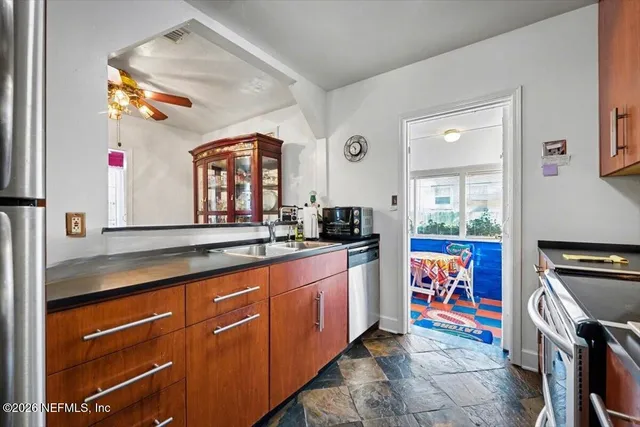 a kitchen with stainless steel appliances granite countertop a sink and a refrigerator