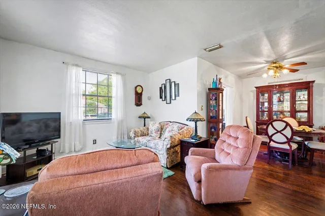 a living room with furniture a flat screen tv and a window
