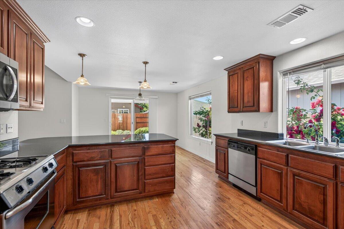2618 Rabun Way Central Point, OR 97502 - Photo 13 of 42 a kitchen with granite countertop a stove and wooden cabinets