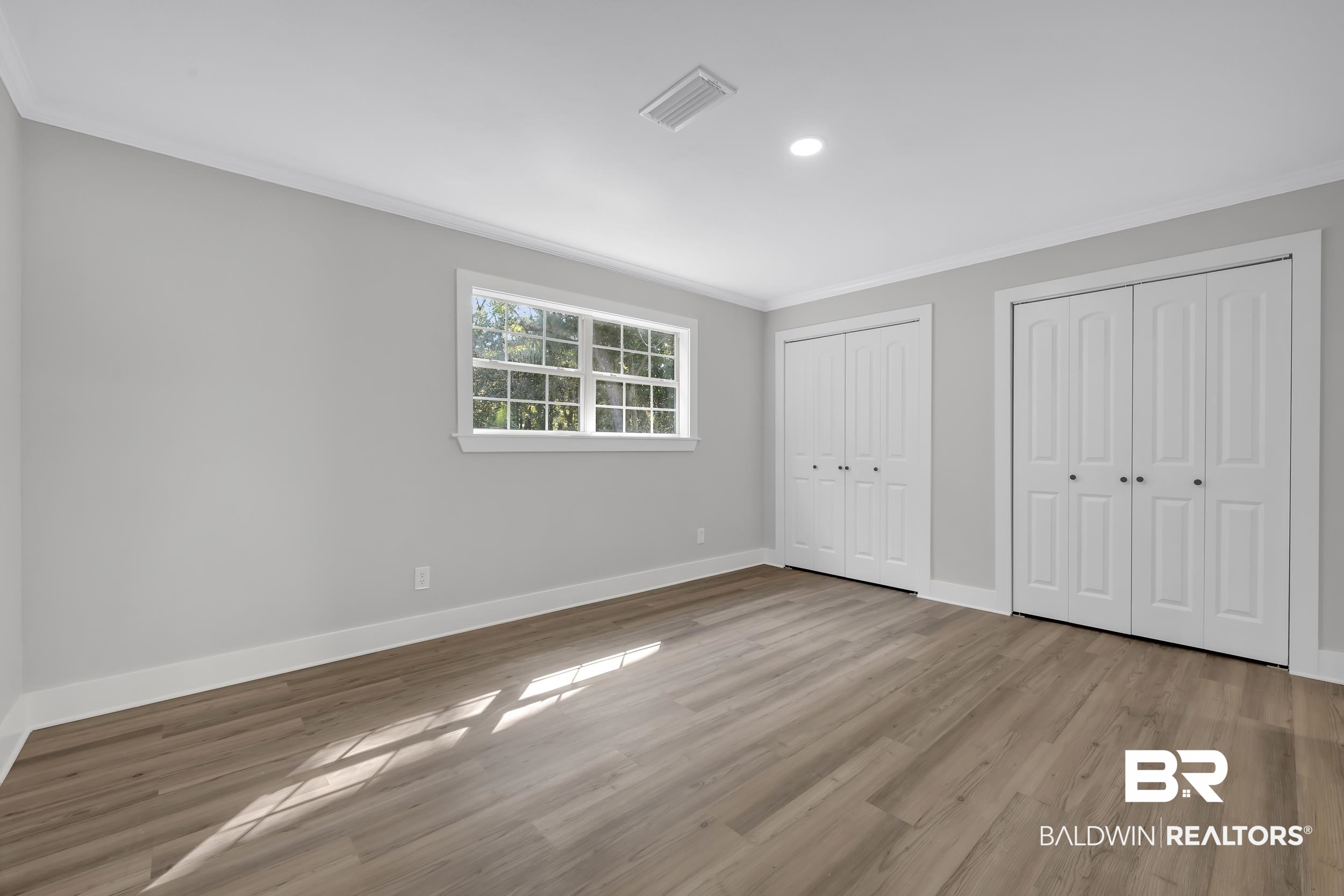 8351 Theodore Dawes Road Theodore, AL 36582 - Photo 14 of 46 Unfurnished bedroom featuring crown molding, multiple closets, light wood-type flooring, and recessed lighting