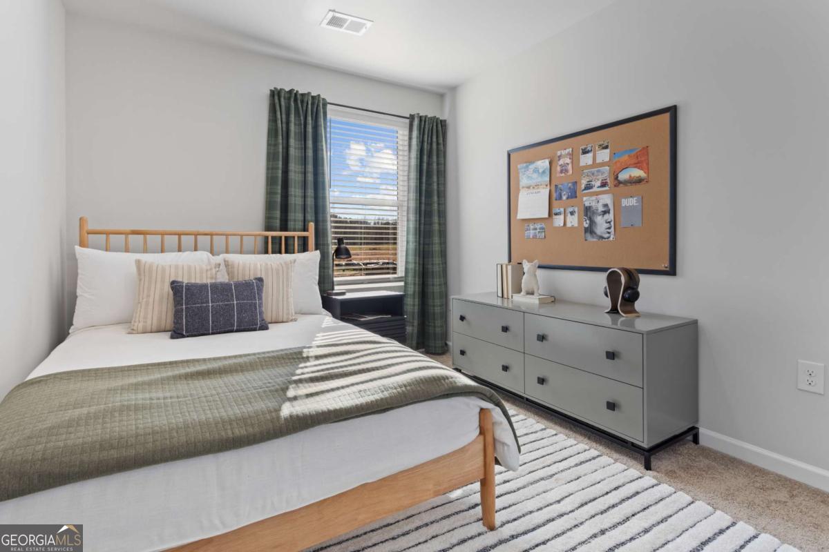 124 Meadowview Drive, Unit 12 Temple, GA 30179 - Photo 19 of 27 a spacious bedroom with a bed and a large window