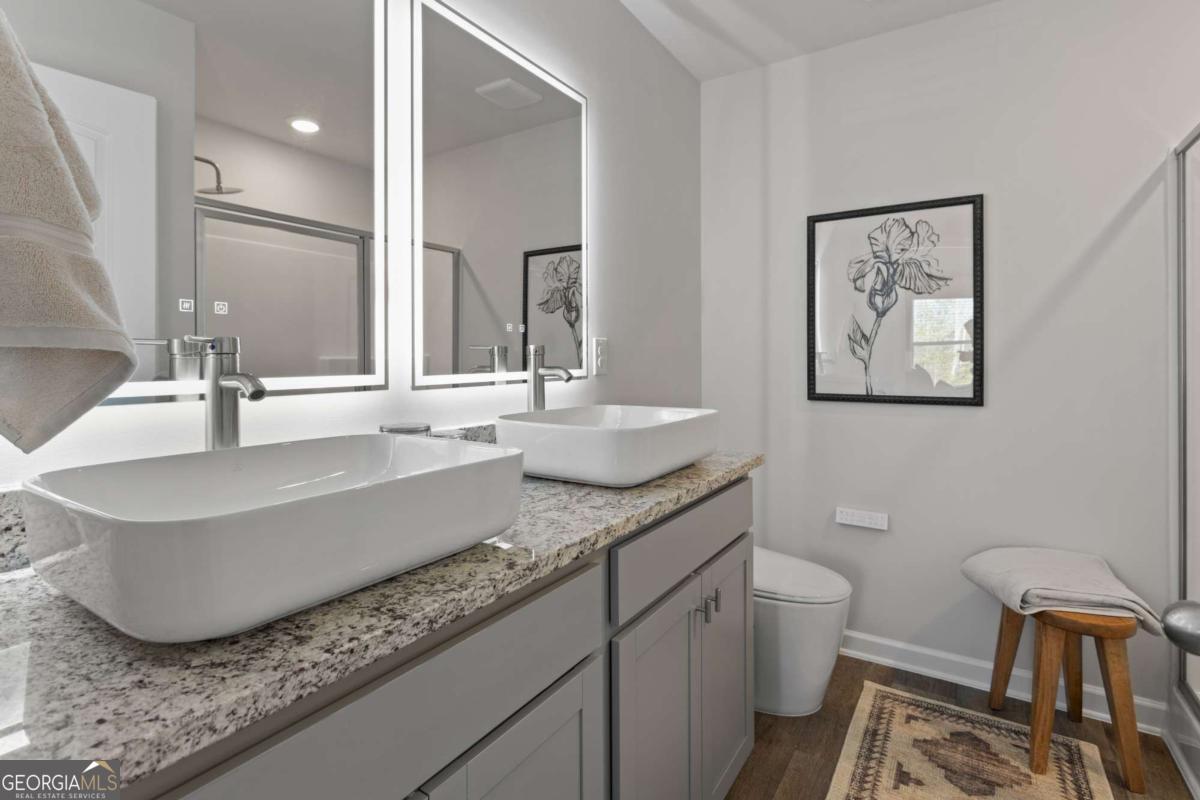 124 Meadowview Drive, Unit 12 Temple, GA 30179 - Photo 23 of 27 a bathroom with a granite countertop sink and a large mirror