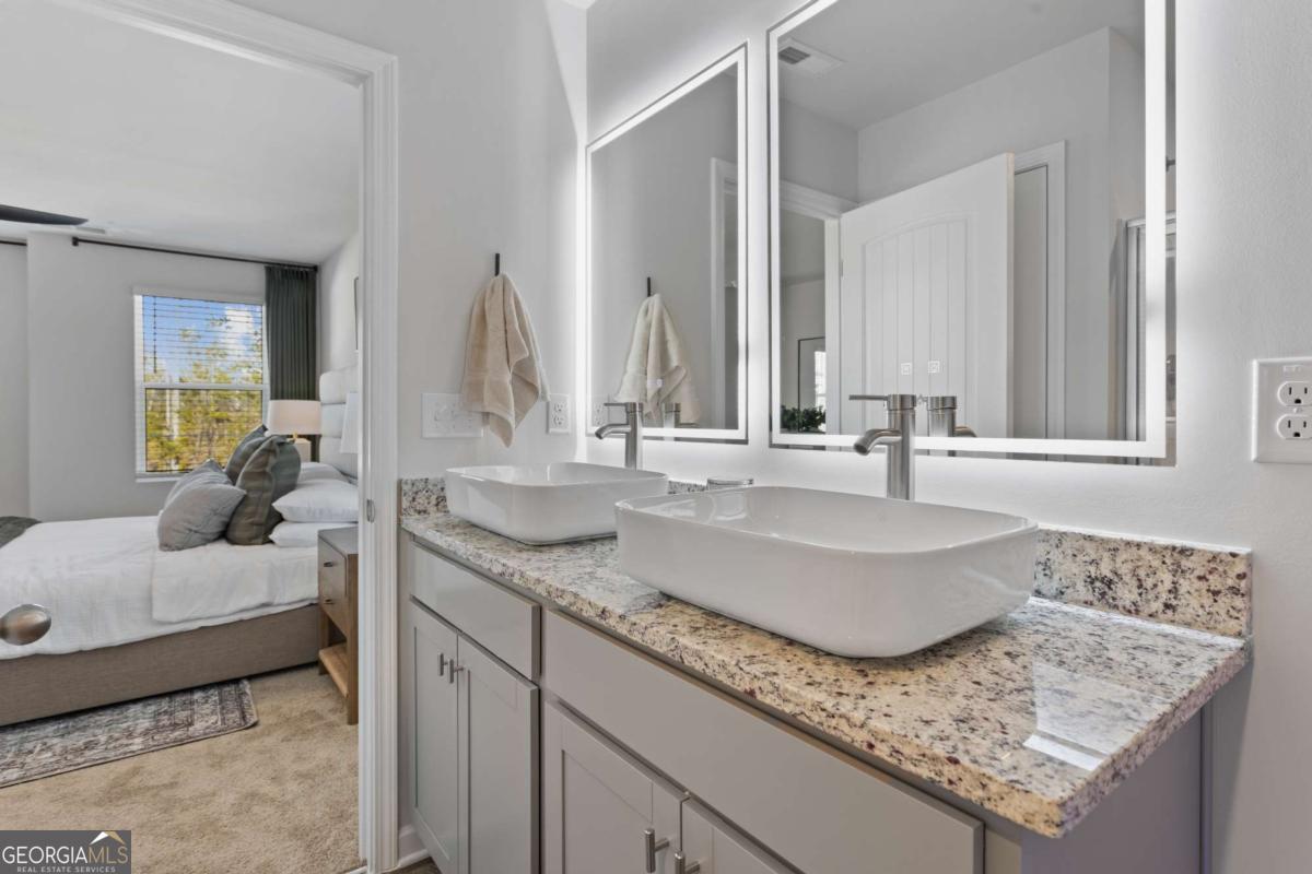 124 Meadowview Drive, Unit 12 Temple, GA 30179 - Photo 24 of 27 a bathroom with sinks granite countertop a sink and a mirror
