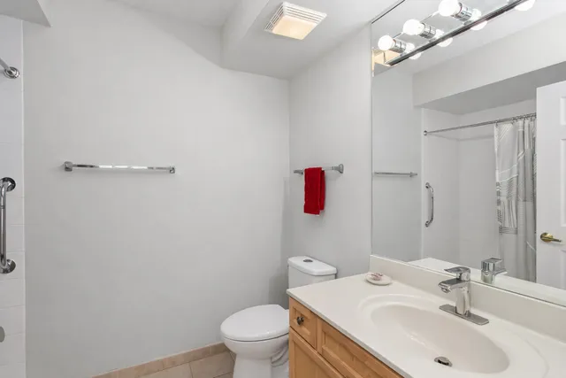 a bathroom with a sink vanity mirror and toilet