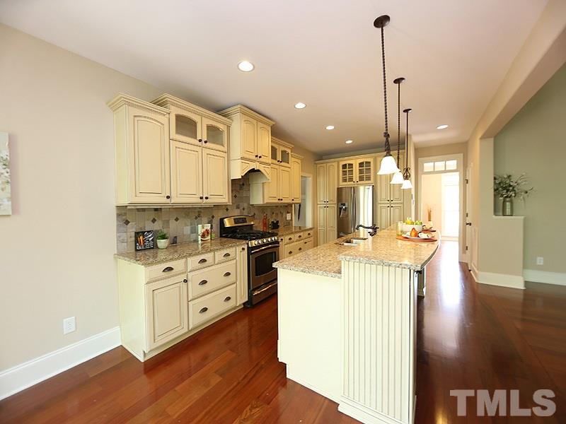 3460 Century Farm Road Wake Forest, NC 27587 - Photo 13 of 25 a kitchen with stainless steel appliances kitchen island granite countertop a stove a sink and a refrigerator