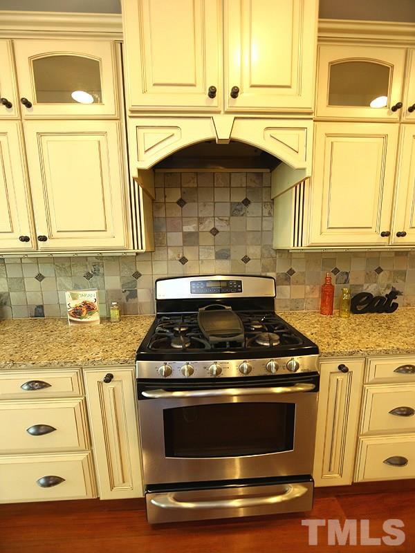 3460 Century Farm Road Wake Forest, NC 27587 - Photo 15 of 25 a kitchen with granite countertop a stove and a white cabinets