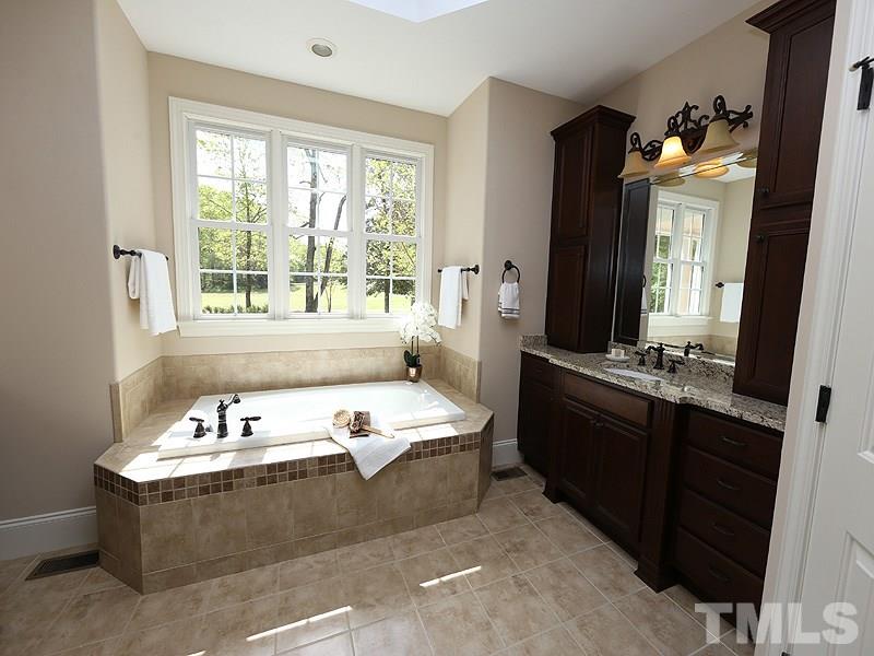 3460 Century Farm Road Wake Forest, NC 27587 - Photo 19 of 25 a bathroom with a tub double vanity sink and mirror