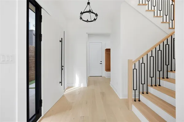 a view of a hallway with wooden floor and stairs