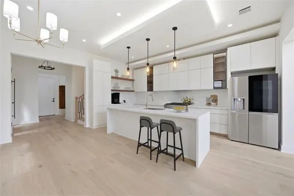 a kitchen with white cabinets and refrigerator