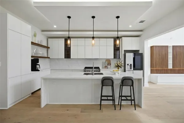 a kitchen with stainless steel appliances granite countertop a sink a stove and a refrigerator