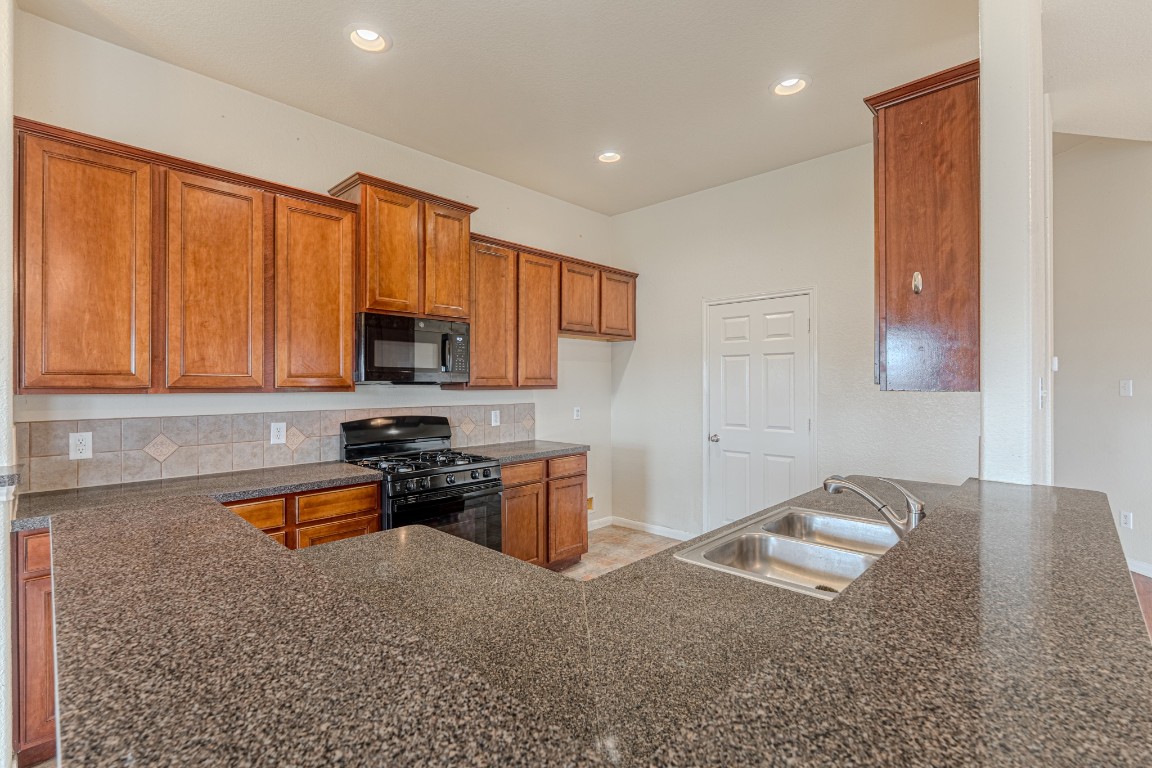 6526 Bella Noche Drive Spring, TX 77379 - Photo 22 of 46 a kitchen with a sink stove and cabinets