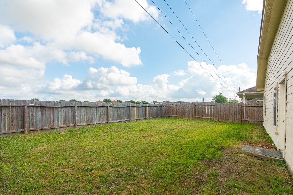 6526 Bella Noche Drive Spring, TX 77379 - Photo 42 of 46 a view of a backyard with a large tree and wooden fence