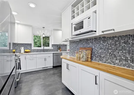 a kitchen with cabinets appliances a sink and a counter top space