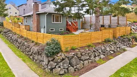 a view of a pathway of a house with a yard and wooden fence