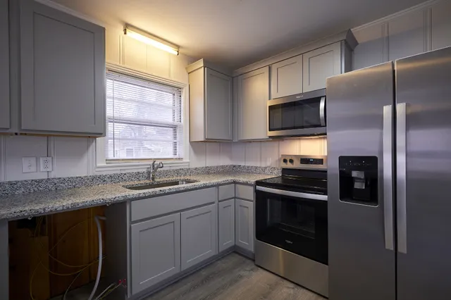 a kitchen with a sink stove microwave and refrigerator