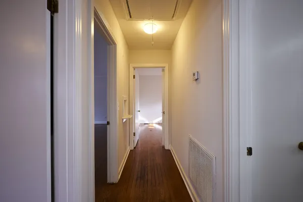 a view of a hallway with a wooden door