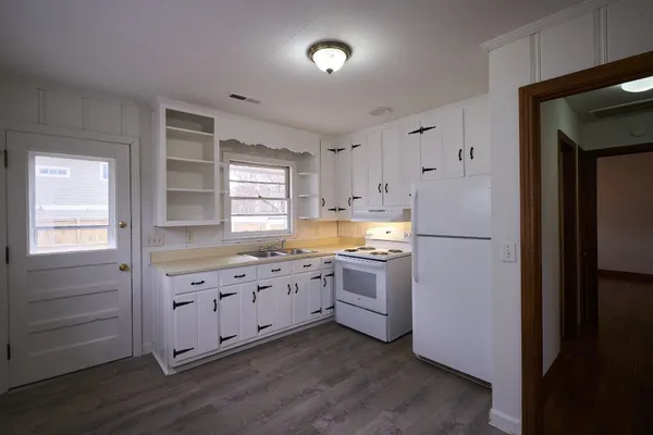 a kitchen with granite countertop white cabinets and stainless steel appliances