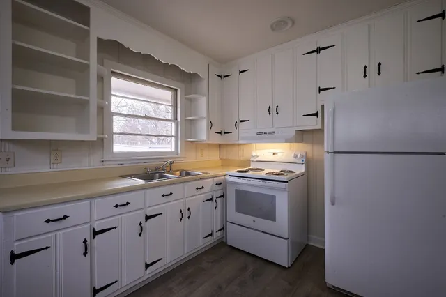 a kitchen with cabinets appliances a sink and a window