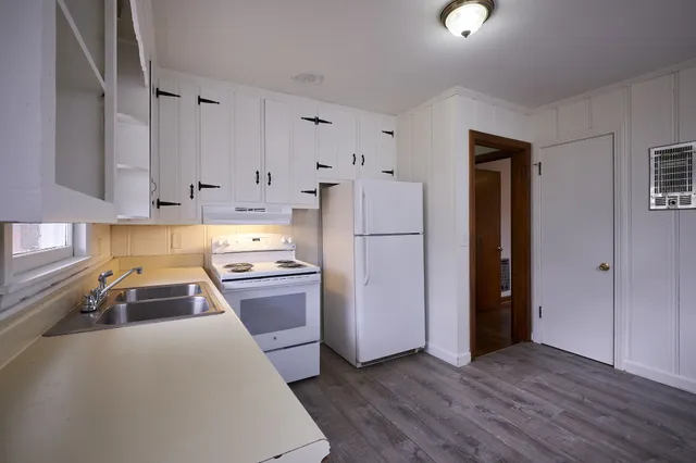 a kitchen with a refrigerator a stove top oven and a sink