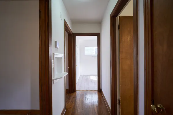 a view of a hallway with wooden floor
