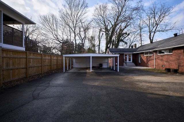 a view of a house with a large tree and a road