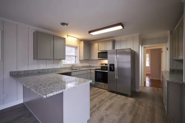 a kitchen with granite countertop a refrigerator and a sink