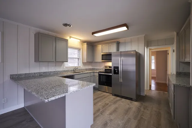 a kitchen with granite countertop a refrigerator and a sink