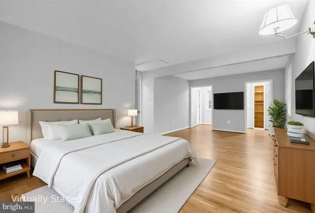 a spacious bedroom with a bed and a flat screen tv