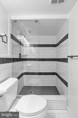 a bathroom with a toilet and a shower