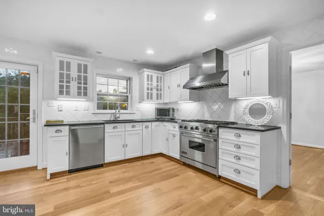 a kitchen with stainless steel appliances granite countertop a stove and a sink