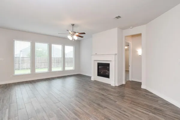 a view of a livingroom with a ceiling fan window and wooden floor