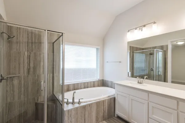 a bathroom with a tub sink and mirror