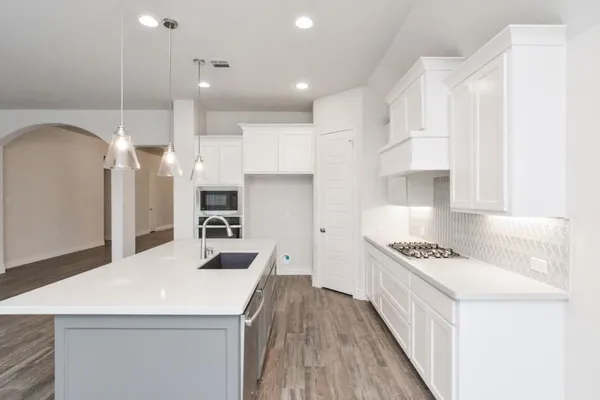 a kitchen with stainless steel appliances kitchen island a refrigerator and a stove top oven