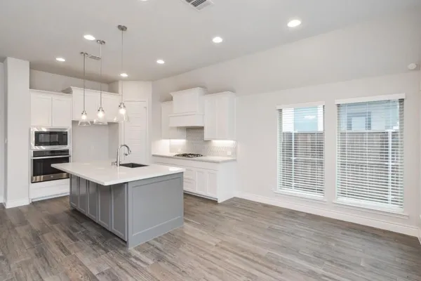 a kitchen with stainless steel appliances sink stove and cabinets