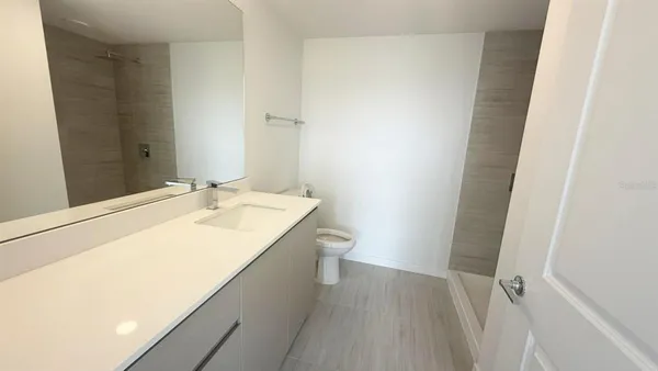 a bathroom with a sink a toilet and a mirror