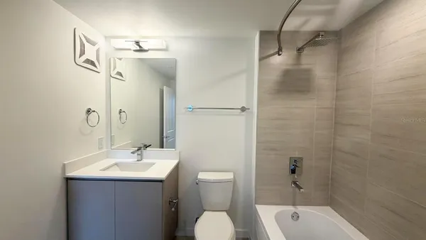 a white bath tub sitting next to a white toilet and sink