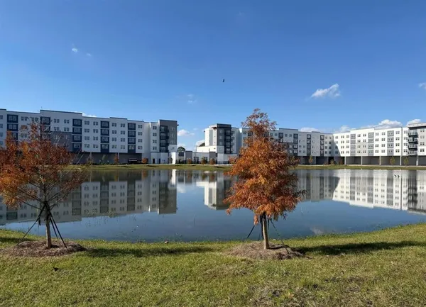 a living room with furniture a chandelier and a dining table with wooden floor