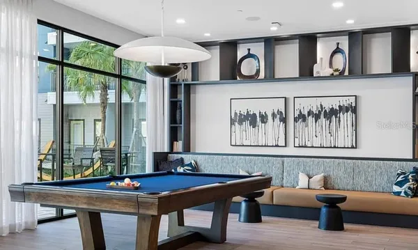 a room with stainless steel appliances kitchen island granite countertop a dining table chairs and a oven