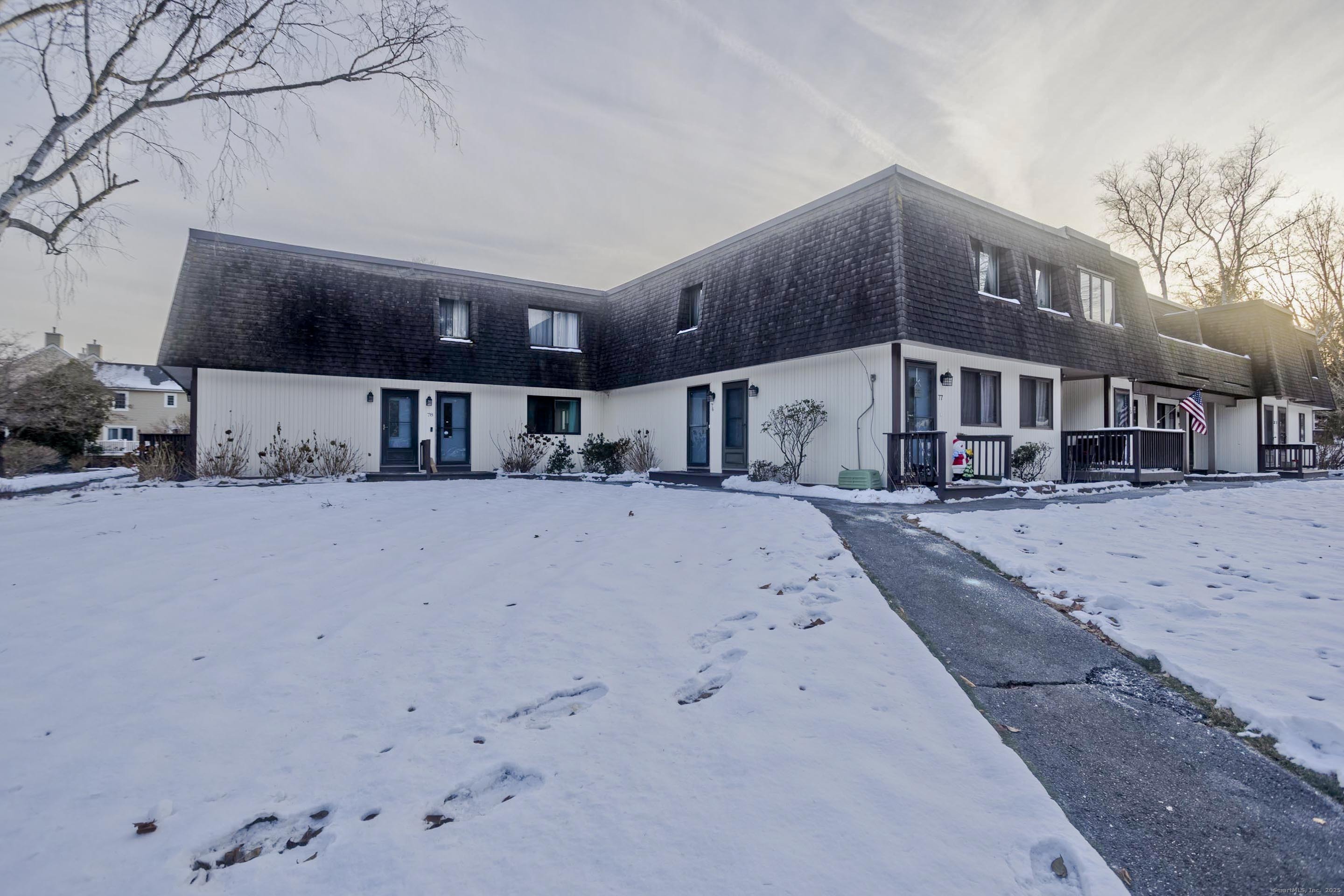 a front view of a house with large tree