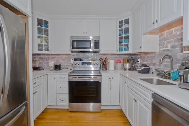 a kitchen with cabinets stainless steel appliances a sink and a counter space