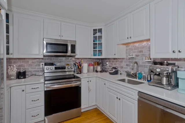 a kitchen with stainless steel appliances refrigerator and dining table