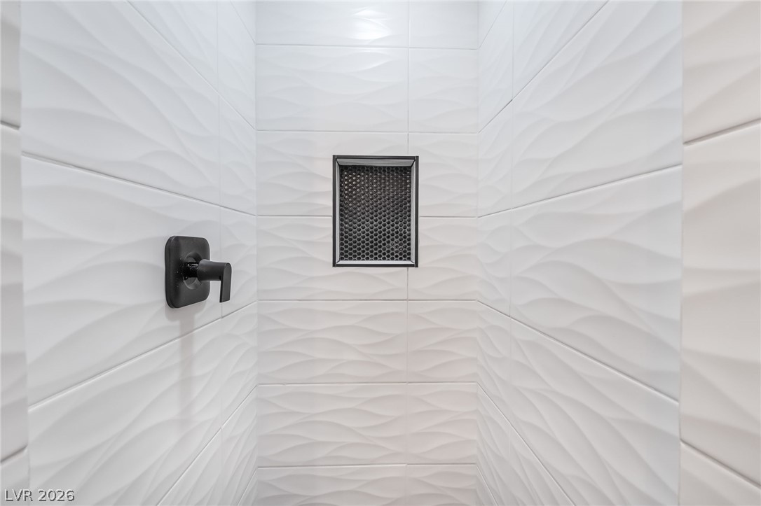 429 Crestway Road Henderson, NV 89015 - Photo 30 of 56 Textured tile creates a dynamic shower enclosure with modern matte black fixtures.