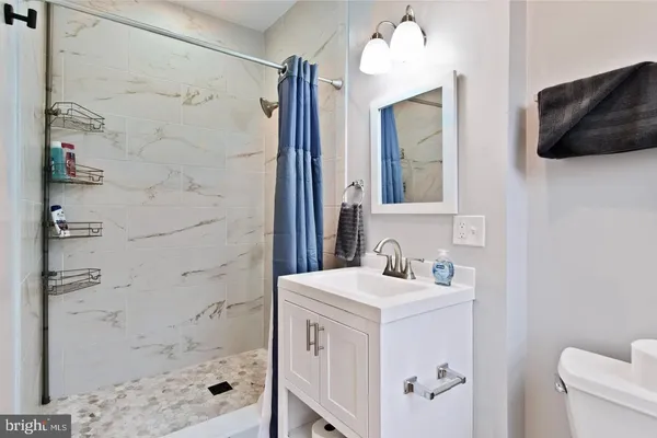 a bathroom with a sink a toilet and shower