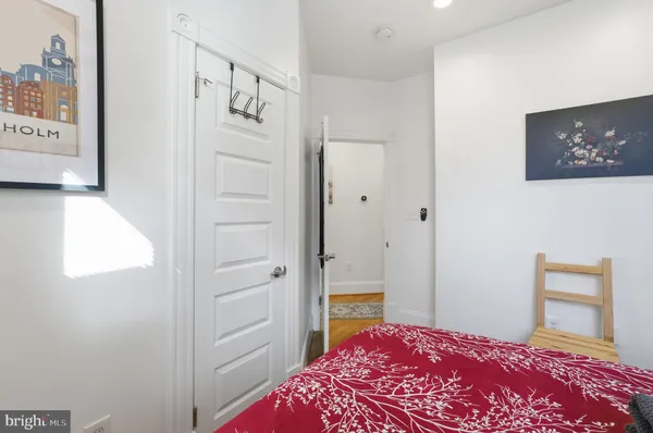 a bedroom with a bed and a lamp on dresser
