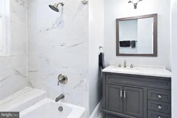 a bathroom with a tub sink and mirror